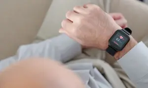 Mężczyzna sprawdza na smartwatchu swój niski puls, który wynosi 63 uderzenia na minutę.