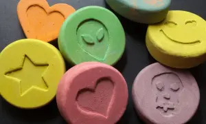 Kolorowe tabletki z symbolami: serce, gwiazda, kosmita, uśmiech, czaszka.