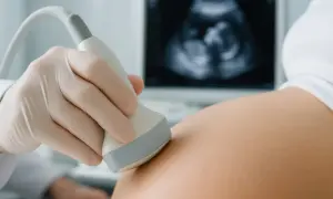 Ginekolog wykonuje USG brzucha ciężarnej. Na ekranie widać obraz płodu, który ma już 6 tydzień ciąży.