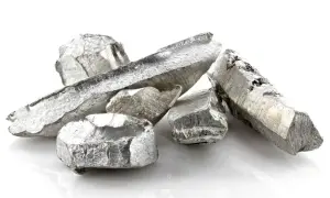 Kawałki metalicznego kadmu o srebrzystym połysku, ułożone na białym tle.