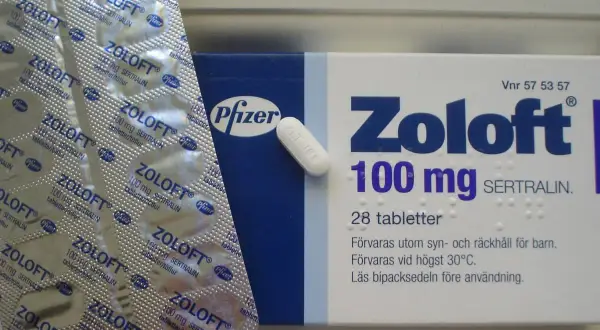 Opakowanie leku Zoloft 100 mg z sertraliną i pojedyncza tabletka.