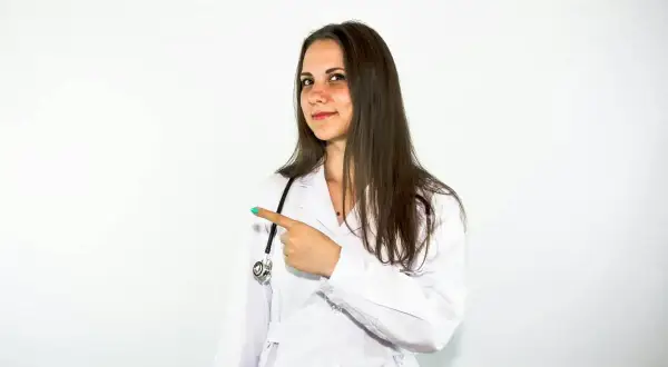 Lekarka w białym kitlu wskazuje palcem, sugerując, że warto rozważyć Locoid Lipocream na problemy skórne.