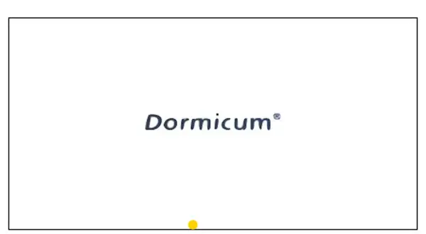 Niebieski napis "Dormicum" na białym tle, z żółtą kropką na dole.